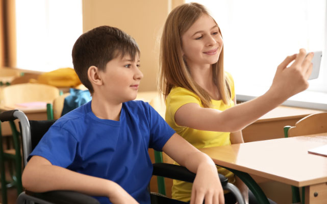 O edukacji włączającej - Dzieci, chłopiec i dziewczynka siedzący przed monitorem wskazują na ekran